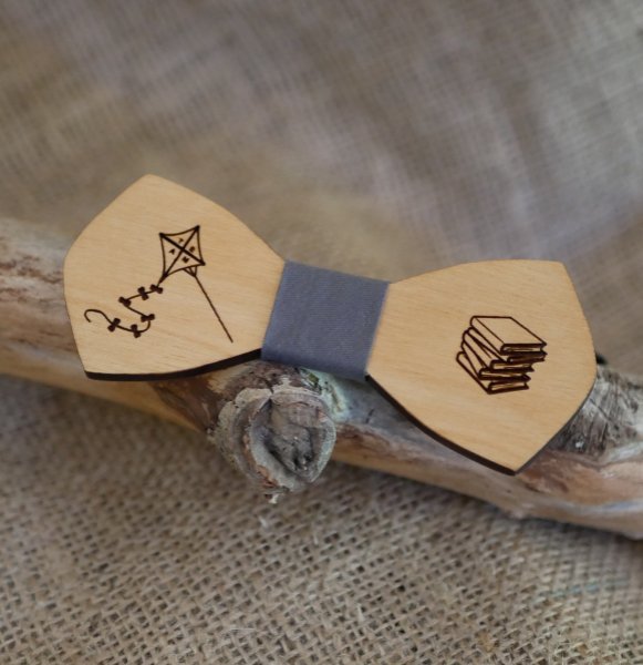 Two drawings engraved on a natural wood bow tie