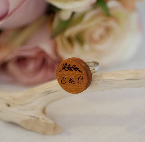 Bague personnalisée en bois gravé avec initiales et fleurs.
